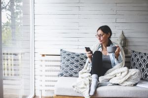 Women sitting on couch using her phone